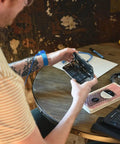 Person using Anti Static Wrist Strap For Electronics Repair And ESD Grounding Wristband With Adjustable XL Size, blue color.