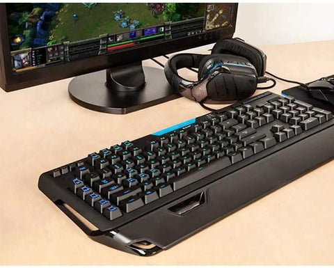The Beast Mode Full Size Mechanical Gaming Keyboard Delivering Snappy Keystrokes With Dynamic Rainbow Backlight beside a gaming monitor.