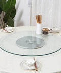 Heavy Duty Tempered Glass Lazy Susan Turntable No Sweat Smooth Spinner For Dining Tables Silent Round Clear Serving Tray For Low Key Family Meals Kitchen Centerpiece 100cm on round dining table with chopsticks and dishes.