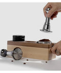 Pro Grade Stainless Steel Espresso Tamper Kit With Auto Rebound For 51 53 And 58 Mm Portafilters in use on wooden base.