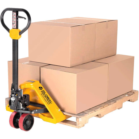 Global Industrial manual pallet jack in yellow with red wheels lifting stacked cardboard boxes on a wooden pallet.