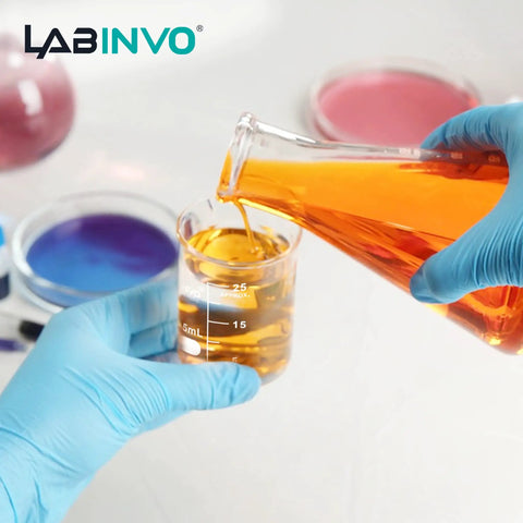 Chemist pouring liquid into a Low Form 10 mL Glass Beaker Set, 12 Pieces, 3.3 Borosilicate Lab Beakers With White Enamel Graduations From 5 to 10 mL, 26 mm OD by 37 mm H, ASTM E960 Type I, Durable, Heat Safe Chemistry Gear.
