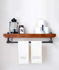 Wooden shelf with Half Inch By Six Inch Black Painted Iron Pipe Nipples Set Of 10 for DIY furniture, holding towels and decor.