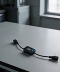 Hella Precise EV Charger Analyzer 8 To 120 Volts And 0 To 10 Amps on a gray table, showing LCD and cables for monitoring EV charging.
