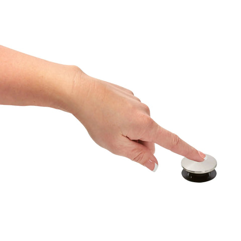 Hand pressing Push And Seal Replacement Stopper 972098J Brushed Nickel for standard sink drains, shown on finger tip