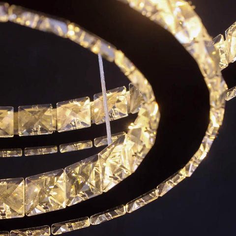 Close-up of Modern 4-Ring Crystal LED Chandelier with K9 crystals and stainless steel, warm white 2700-3500K lighting.
