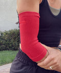 Woman wearing red Elbow Sleeve For Joint Pain Relief And Inflammation Reduction With Circulation Boost All Day Comfort outdoors