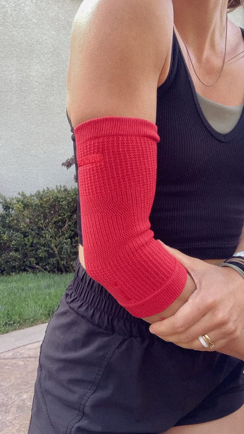 Woman wearing red Elbow Sleeve For Joint Pain Relief And Inflammation Reduction With Circulation Boost All Day Comfort outdoors