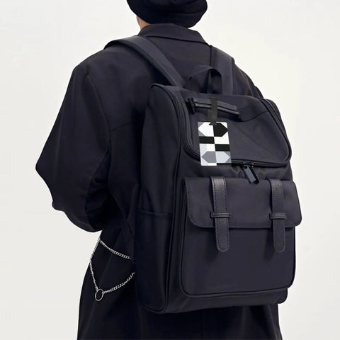 Compact Black And White Piano Grid Print Luggage Tags With Personalized Name Tags For Slick Travel Setup visible on black backpack.