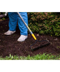 Person using Steel 16 Tine Bow Rake With 57 Inch Hardwood Handle And Cushy Grip For Small Yard Work And Landscaping Projects Durable Garden Rake For Yard Cleanup Made In USA Everyday Use on mulch
