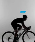 Cyclist on road bike silhouette with "AGILLE" speech bubble overhead, wearing helmet and cycling attire, gray background.