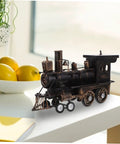 Locomotive Model Retro Steam Train Sculpture For Desktop Decoration on white table beside fruit bowl.