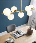 Groovy Mid Century Modern Pendant Light Set Featuring Sleek Glass Globes and Gold Finish Perfect for Kitchen Island or Dining Room with Seven Bulbs for a Rad Lighting Vibe and Dimmable LED Compatibility above a dining table.