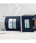 Side view of permanent magnet DC gear motor with brake, blue housing, orange shaft, 120W, 12/24V