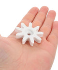 4 Piece 9 Tooth Plastic Gear Set for Gumball Machines and Coin Operated Dispensers shown in hand for size reference.