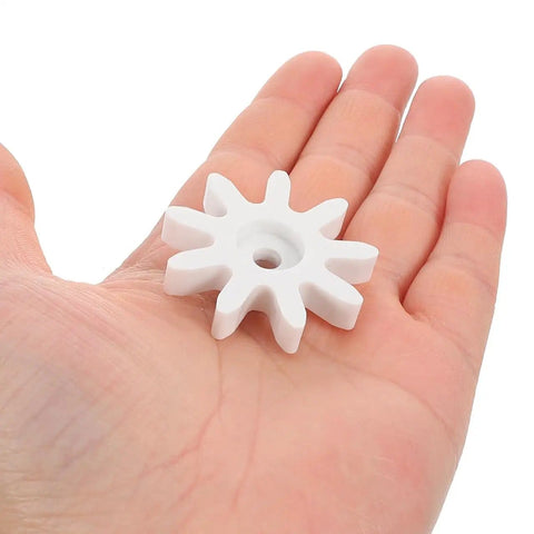 4 Piece 9 Tooth Plastic Gear Set for Gumball Machines and Coin Operated Dispensers shown in hand for size reference.