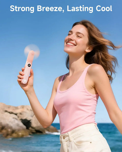 Woman using Portable Handheld Mini Fan With LED Display, 3-in-1 USB Rechargeable Fan And Flashlight For Travel by the sea