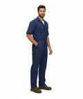 Essential Men's Short Sleeve Zip Up Coverall in Navy Blue worn by man, made from durable poly cotton blend for heavy duty tasks.