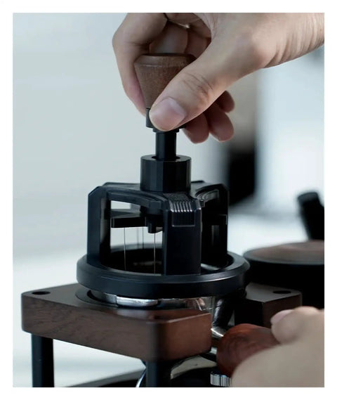 Hand using a Heavy Duty 58 Millimeter Espresso Portafilter Needle Distributor With Built In Magnet for even coffee grounds.