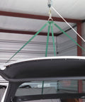 Rope Hoist 50 Ft 5 To 1 Block And Tackle Pulley System lifting a car roof in a garage with green straps and zinc-plated hooks