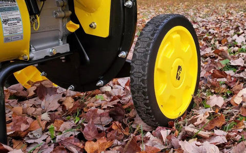 Side view of tire and frame of Heavy-Duty 3 Inch Portable Chipper Shredder With Collection Bag And 224cc OHV Engine For Fast Yard Cleanup Handles Branches Up To 3 Inches Gas Powered Easy Mobility on fallen leaves