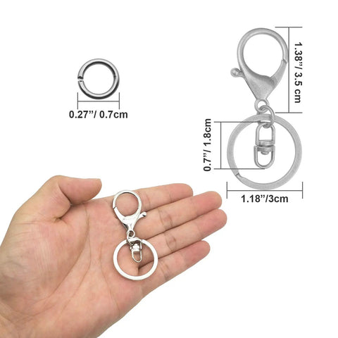Top Shelf 30 Pc Lobster Clasp Keychain Set With Hella Strong Swivel Hooks Plus 100 Open Jump Rings For Diy Jewelry Making And Craft Repair. Hand holding a lobster claw keychain with a jump ring.