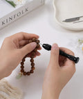 Hands using Badass Mini Micro Drill Bit Set With Tough Pin Vise on wood bead jewelry for DIY projects.