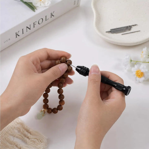 Hands using Badass Mini Micro Drill Bit Set With Tough Pin Vise on wood bead jewelry for DIY projects.