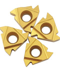 Four gold carbide turning inserts with center holes for CNC lathe threading.