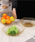 Golden Iron Fruit Basket For Fruits And Vegetables With Draining Water Feature And Geometric Wire Design displayed on table