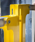 Close-up of Heavy Duty Cantilever Dock Gate 12 Foot Wide Double Action Slick Pneumatic Struts, yellow steel frame, mounting detail.
