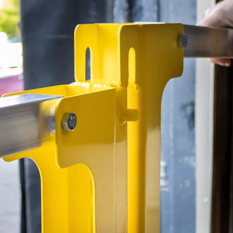 Close-up of Heavy Duty Cantilever Dock Gate 12 Foot Wide Double Action Slick Pneumatic Struts, yellow steel frame, mounting detail.
