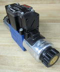 Solenoid directional valve R978024163 4WE6Q62/EG24N9DK24L/62 single unit with 24VDC coil and 4-pin male connector on wooden surface