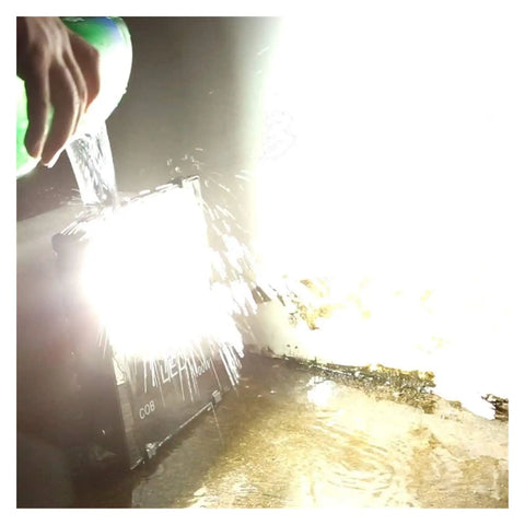 JUDYSSY Courtyard Light Led Solar Flood Light Outdoor being splashed with water to demonstrate IP66 waterproof feature.