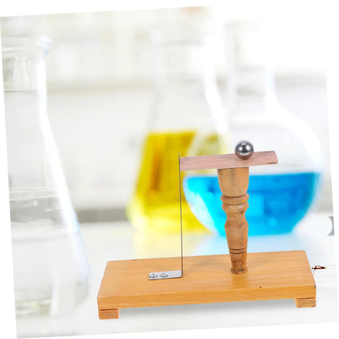 Pendulum Ball Inertia Demonstration Kit for Classroom Physics showing wooden base with metal ball and colored liquid flasks in background.