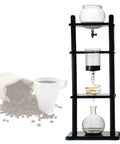 Grab Your Mug And Enjoy This Hella Smooth Cold Brew Coffee Maker Dripper Tower Featuring Slow Drip Extraction And 1000ml Capacity For Pulling Fresh Ice Coffee Concentrates On Demand with a black wood base and glass tower.