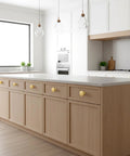 Modern kitchen with Six Pack Gold Cabinet Knobs With Brushed Brass Finish For Dresser And Drawer Doors installed on light wood cabinets.
