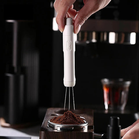 Dope Pink Magnetic Telescopic Coffee Distribution Needle And Rock Solid Stainless Steel Espresso Grounds Leveler for zero clumping, in hand over coffee grounds.
