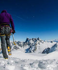 Hiker with Ski Tour New-Matic Crampons for Ski Touring with Ultra Lightweight, Bomb Proof Front Bail on snowy mountain summit