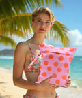 Person holding Coral Pink Polka Dot Wet Bag And Dry Bag For Beach And Pool Waterproof, Machine Washable Swim Tote on beach