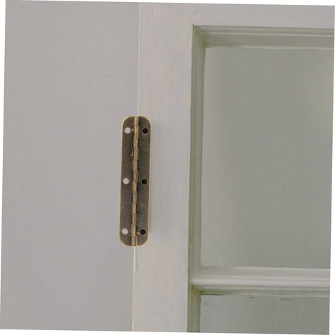 Brass piano hinge installed on white door, edge view