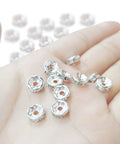 Hand holding 200 Pcs Crystal Rondelle Spacer Beads 8mm Silver Plated for jewelry making and beadwork, showing shiny bright silver finish