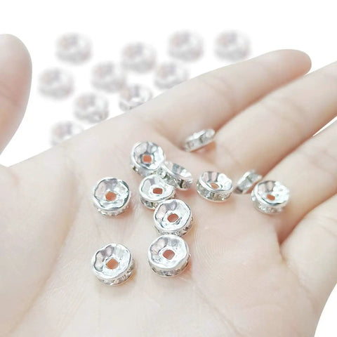 Hand holding 200 Pcs Crystal Rondelle Spacer Beads 8mm Silver Plated for jewelry making and beadwork, showing shiny bright silver finish