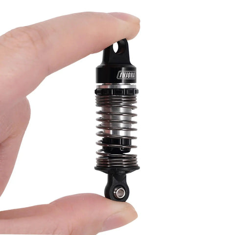 59mm Aluminum Oil Shocks With Adjustable Damping For Mojave Typhon Granite GROM RC Cars held between fingers close-up