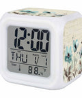 Works Like A Charm Digital Alarm Clock With Spring Blossom Cube Look showing time, date, and temperature, compact white plastic design.