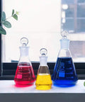 3 Piece Glass Erlenmeyer Flask Set 50ml 150ml 250ml with red, yellow, blue liquids, narrow mouth, stoppers, printed graduation