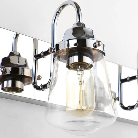 Close-up of Chrome Vanity Light Fixture for Bathroom Three Light Farmhouse Style Over Mirror with Clear Glass Shades