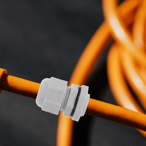 Close-up of a nylon adjustable cable gland on an orange cord for moisture-resistant sealing, part of the 25 Pack Nylon Adjustable Cable Glands Waterproof Cord Grips Heavy Duty Joint Connectors 3-15mm Range Built Tough For Any Electrical Setup Weather Resistant Seal Locks Wires Tight Never Let Moisture In Your Badass Wire Protection Gear.