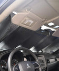 Thermal blocking auto sunshade installed in car interior, enhancing comfort for Level Up Your Slick Ride With This Premium Car Accessory Gift Bundle Featuring Thermal Blocking Auto Sunshade Two Tone Carpet Floor Mats And Ergonomic Grip Steering Wheel Cover For Trucks Vans SUVs.