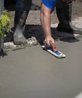 Man using White Lightning Hand Float For Concrete, 16 Inch Blade By 3 Inch, Smooths Bleed Water To The Surface on wet concrete
